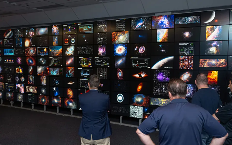 Chercheurs examinant des modèles scientifiques sur le système de visualisation Hyperwall de la NASA